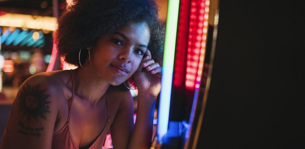 USA, Nevada, Las Vegas, portrait of young woman at slot machine in a casino